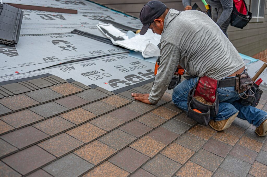 Roofer installing asphalt shingles during a roof repair